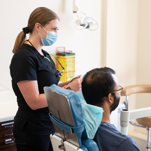 about-2 Dr. Sekhon treating a patient in Ottawa at her dental office on Carling