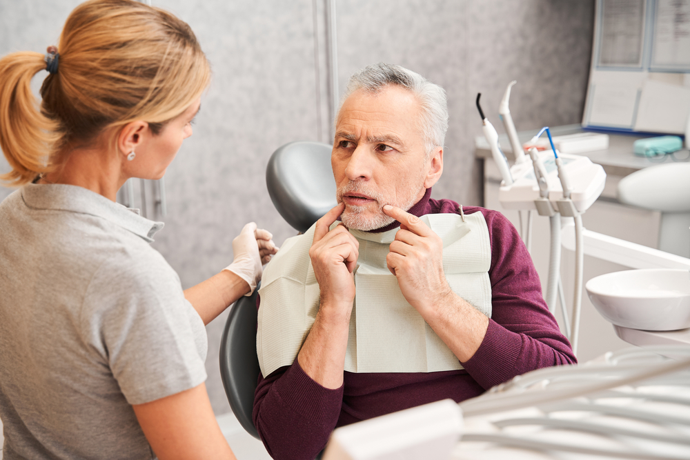 Patient explaining his dental emergency to a dentist