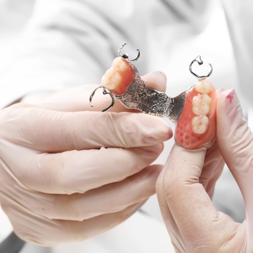 shutterstock_247106044 woman placing her Invisalign trays on her teeth