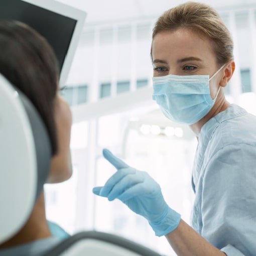 Female Dentist Discussing Teeth Whitening Process With Patient