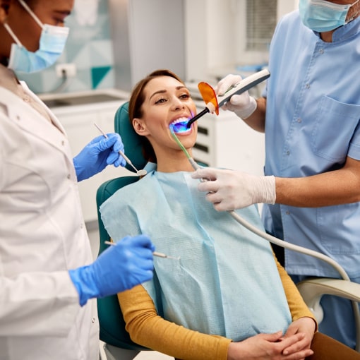 Patient Getting Teeth Whitened With Whitening Solution and UV Light