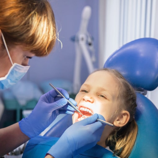 Little girl getting teeth checked at her regular hygiene appointment with a family dentist