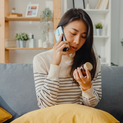 Woman calling Sekhon Dental from her family room for emergency dental appointment