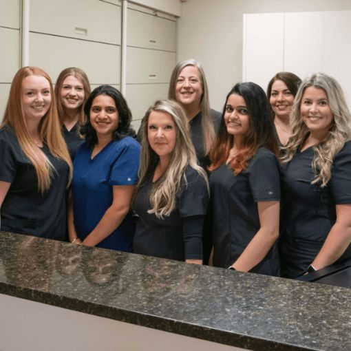 Sekhon Dental Team Sekhon Dental Team Smiling For an Office Picture in Their Scrubs
