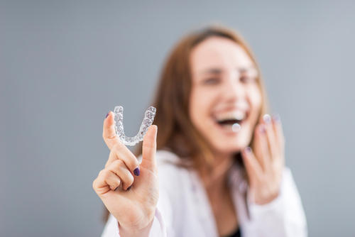 Woman Holding Invisalign Braces - Invisalign Ottawa