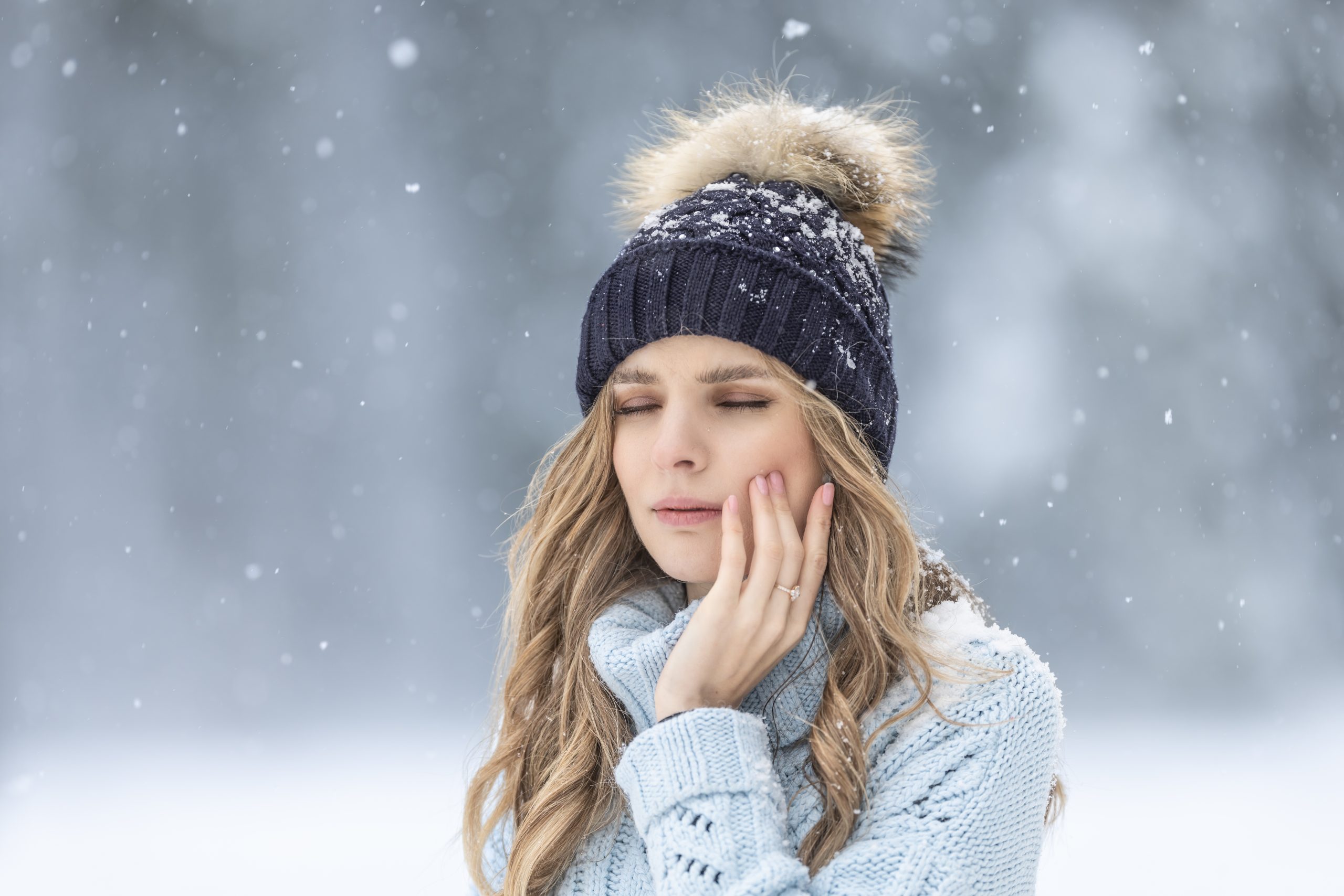Woman with a tooth ache in the snow