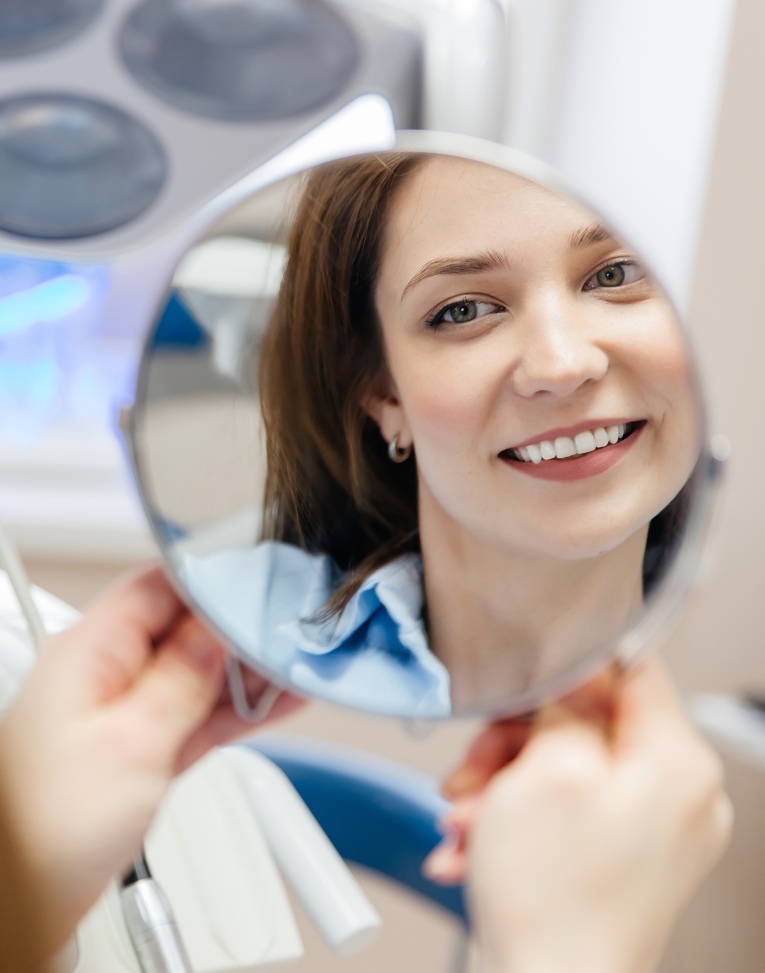woman placing her Invisalign trays on her teeth