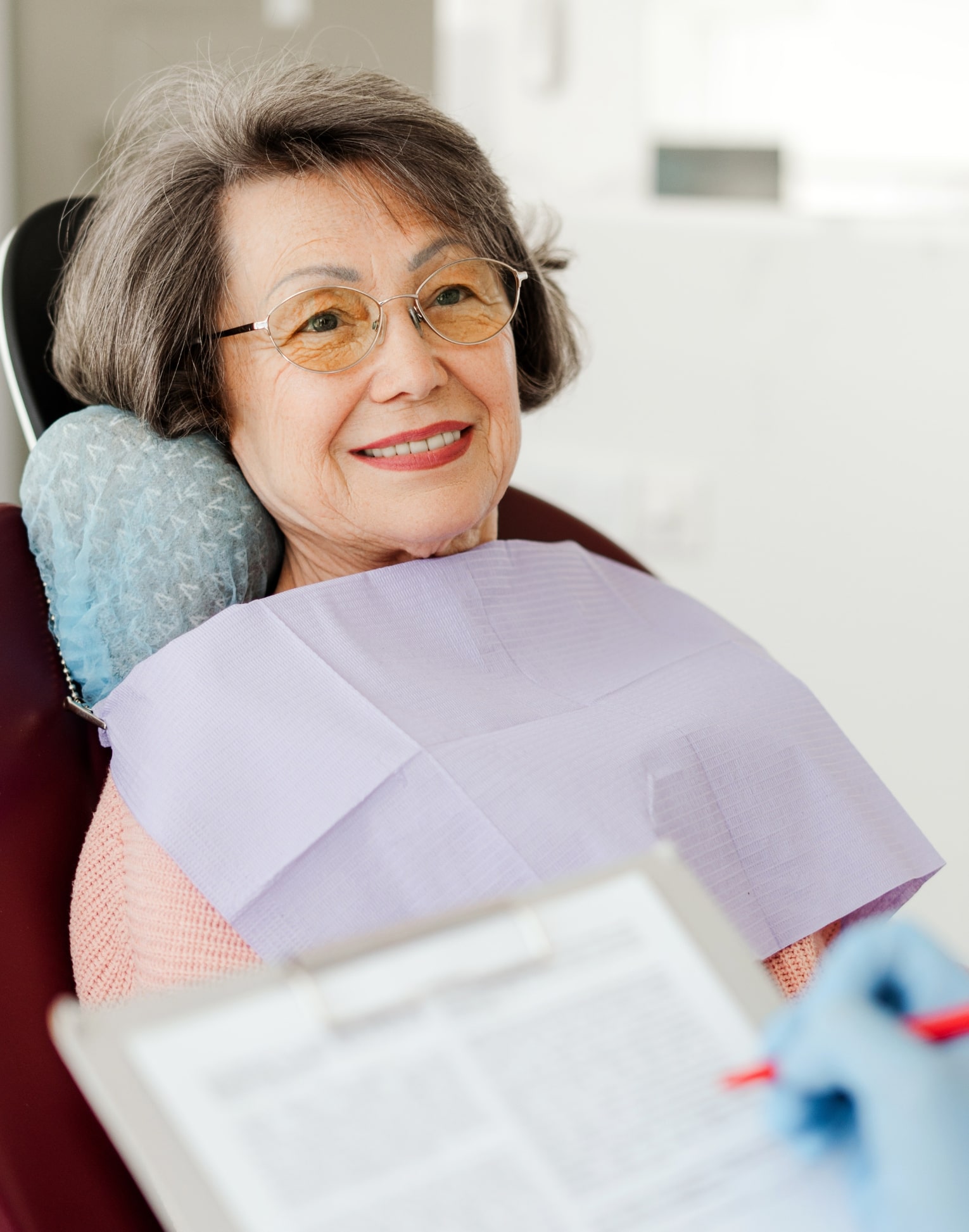 dental implants woman placing her Invisalign trays on her teeth