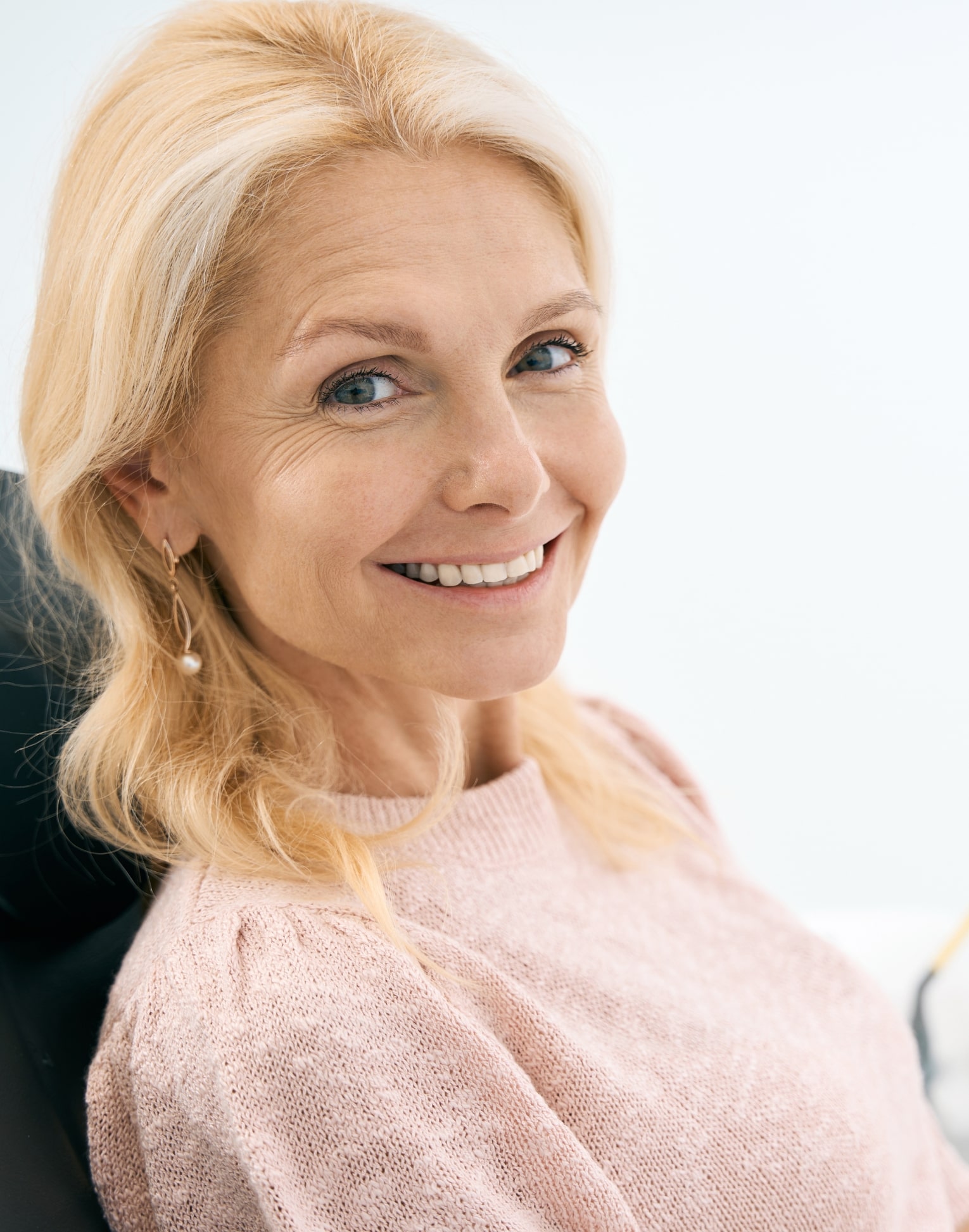 woman placing her Invisalign trays on her teeth